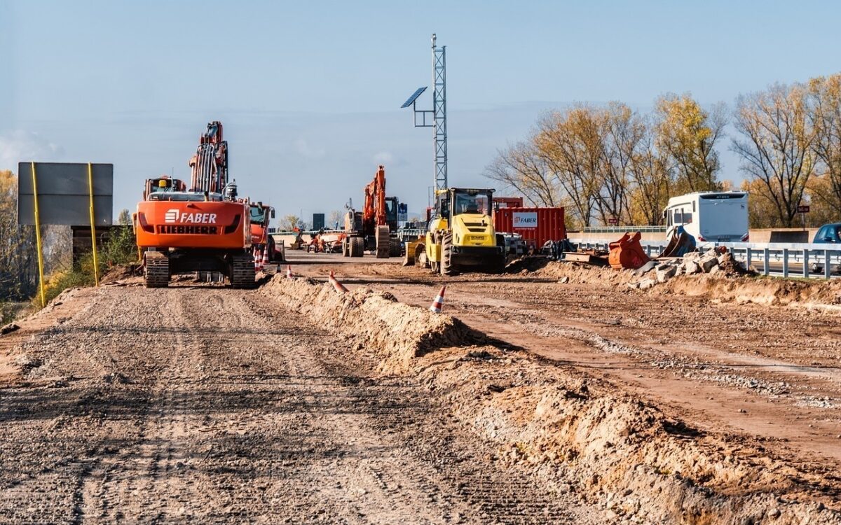 Eine Baustelle auf der Autobahn mit Stau und Bagger Eine Baustelle auf der Autobahn mit Stau und Bagger